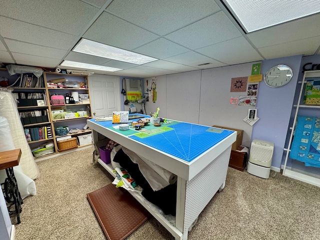 recreation room featuring carpet flooring and a paneled ceiling