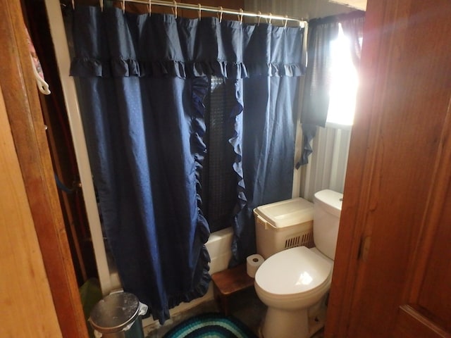 bathroom with shower / tub combo and toilet