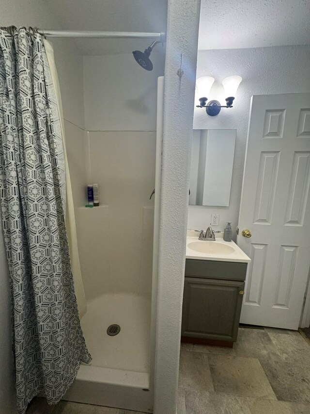 313 E 6th St, Milan, MO 63556 - full bath with a stall shower, vanity, and a textured wall