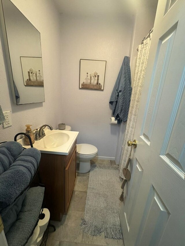 313 E 6th St, Milan, MO 63556 - full bathroom featuring vanity, baseboards, and toilet
