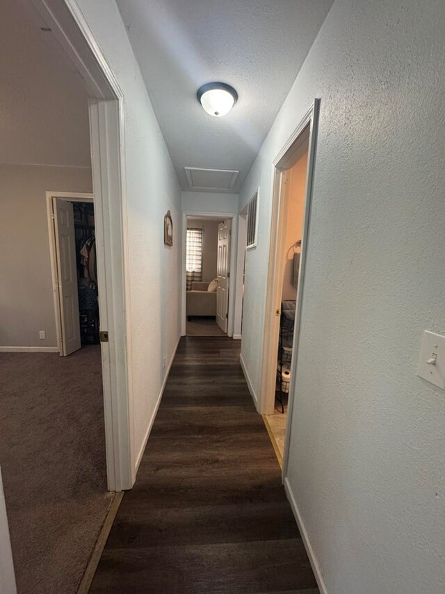 313 E 6th St, Milan, MO 63556 - corridor with a textured wall, baseboards, and dark wood finished floors