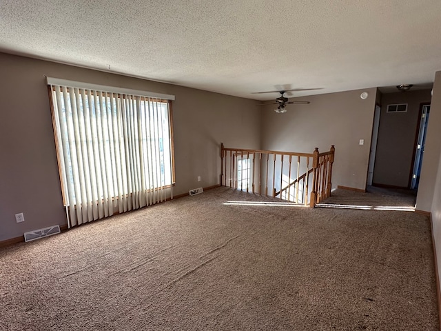 unfurnished room featuring carpet flooring, ceiling fan, and a textured ceiling