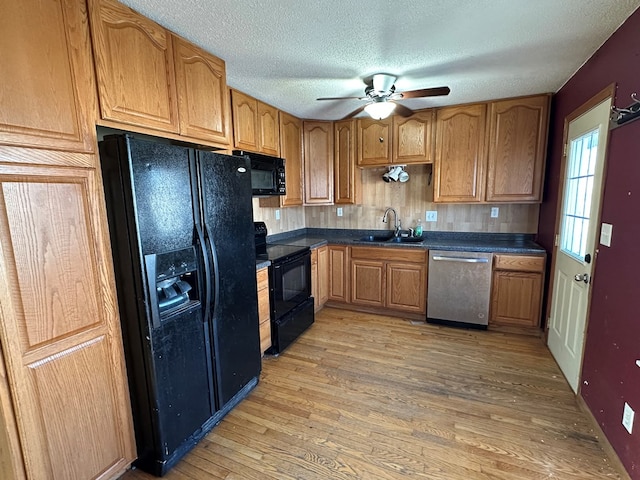 kitchen with a textured ceiling, ceiling fan, sink, black appliances, and hardwood / wood-style floors