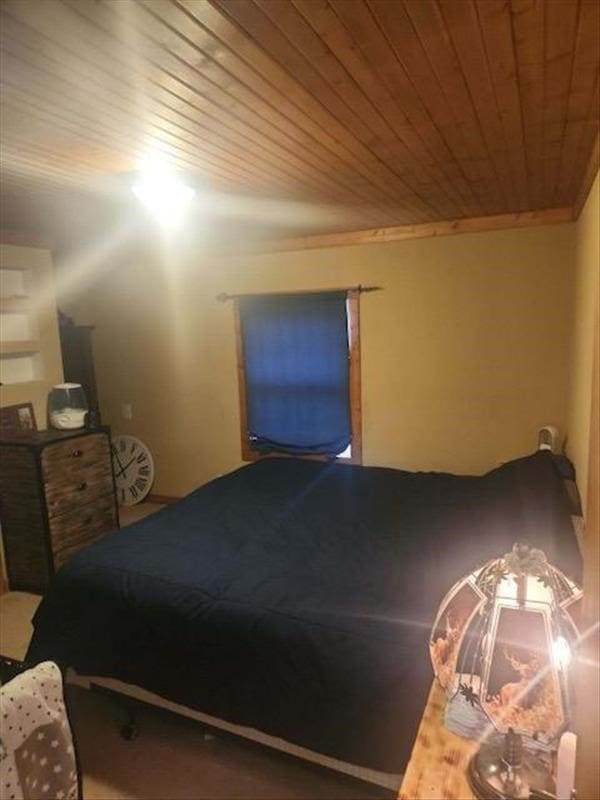 bedroom featuring wood ceiling and ornamental molding