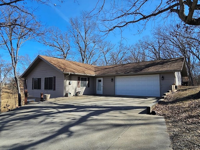 ranch-style home featuring concrete driveway and a garage