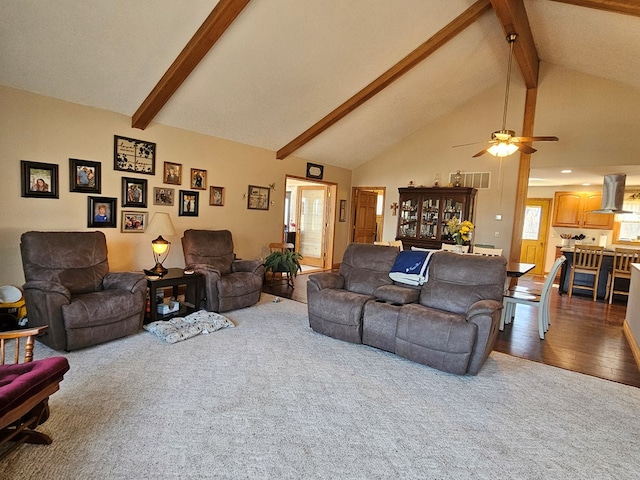 living area featuring visible vents, beam ceiling, wood finished floors, high vaulted ceiling, and a ceiling fan