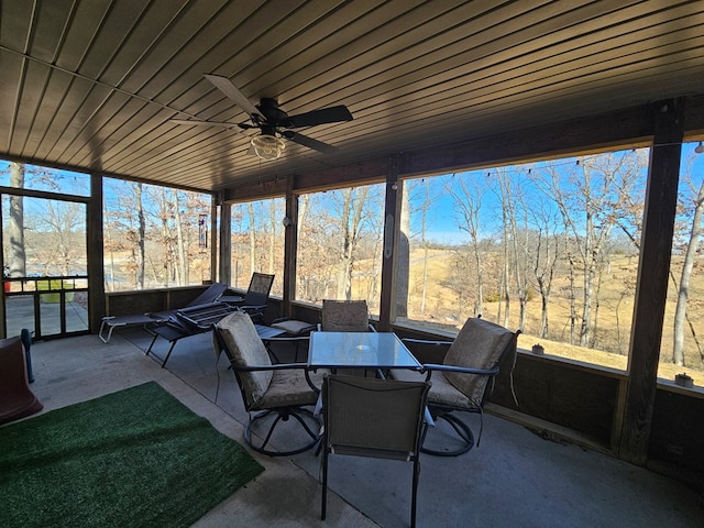 sunroom / solarium featuring outdoor dining area and ceiling fan