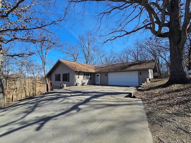 ranch-style house with concrete driveway and an attached garage