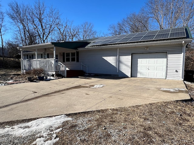 113 N Cottage Grove Ave, Kirksville, MO 63501 - view of front of home featuring a garage, roof mounted solar panels, a porch, and concrete driveway