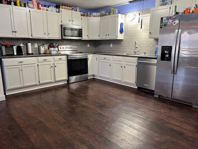 113 N Cottage Grove Ave, Kirksville, MO 63501 - kitchen with a sink, stainless steel appliances, dark countertops, and dark wood-style flooring