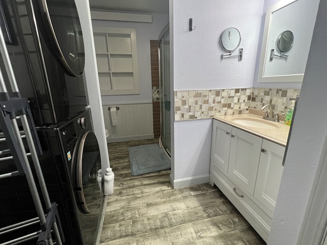 113 N Cottage Grove Ave, Kirksville, MO 63501 - full bathroom featuring vanity, wood finished floors, a wainscoted wall, stacked washing maching and dryer, and a stall shower