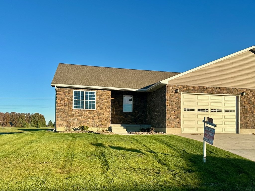 single story home featuring a front lawn and a garage