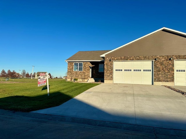 ranch-style house featuring a garage and a front lawn