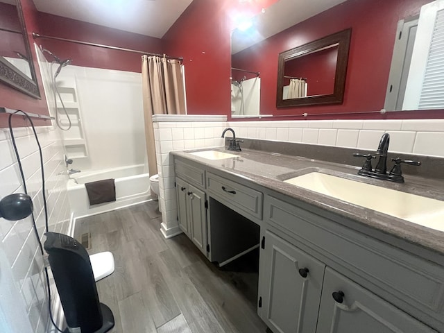 1713 Fairchild St, Chillicothe, MO 64601 - full bath with tile walls, wood finished floors, double vanity, and shower / bath combo