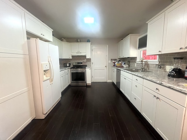 1713 Fairchild St, Chillicothe, MO 64601 - kitchen featuring stainless steel appliances, backsplash, white cabinets, dark wood-style flooring, and under cabinet range hood