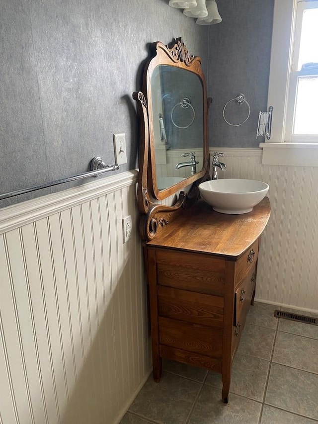 911 Cherry St, Chillicothe, MO 64601 - bathroom with vanity, radiator heating unit, tile patterned flooring, and wainscoting