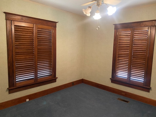 911 Cherry St, Chillicothe, MO 64601 - empty room with crown molding, carpet floors, baseboards, visible vents, and ceiling fan
