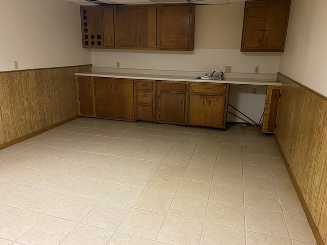 911 Cherry St, Chillicothe, MO 64601 - kitchen featuring light countertops, a sink, wooden walls, and wainscoting
