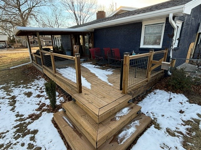 snow covered deck with a porch