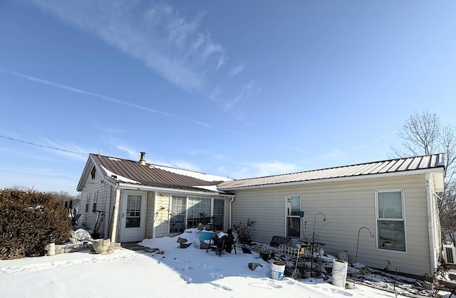 view of snow covered rear of property