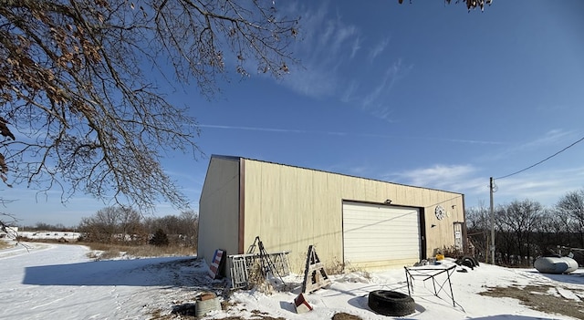 snow covered structure featuring a garage