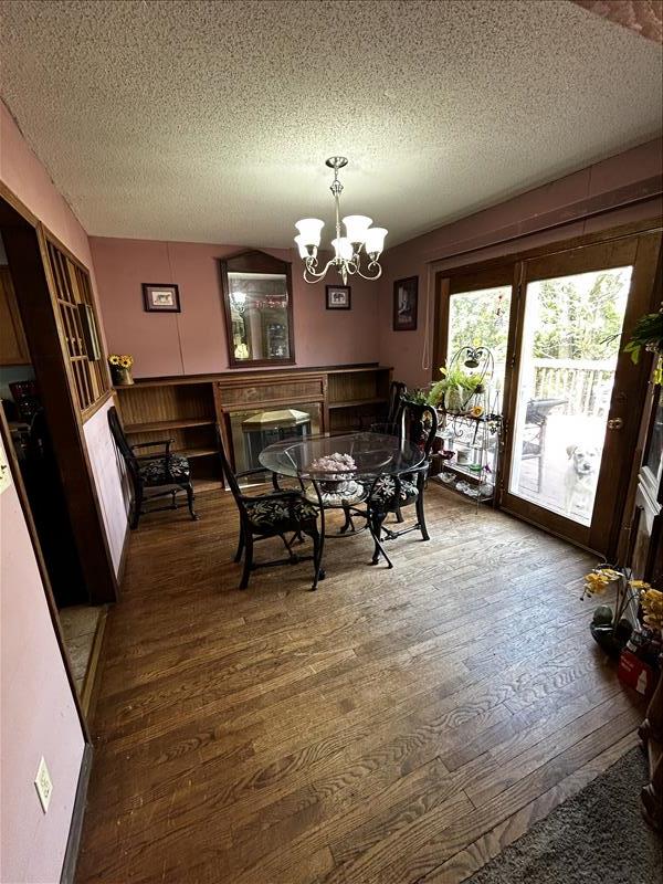 803 Coates St, Macon, MO 63552 - dining room with a textured ceiling, wood finished floors, and a chandelier