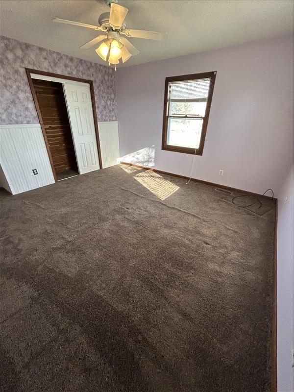 803 Coates St, Macon, MO 63552 - unfurnished bedroom with wallpapered walls, a wainscoted wall, carpet, and a closet