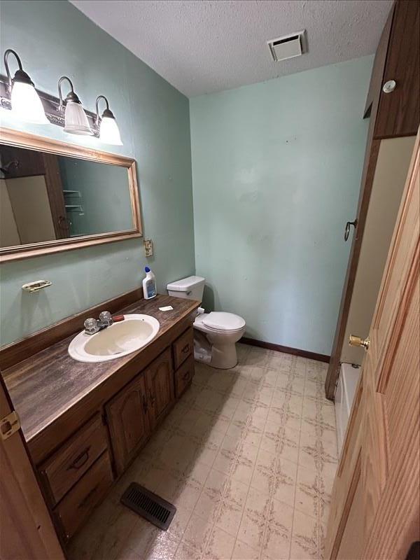 803 Coates St, Macon, MO 63552 - bathroom with vanity, toilet, a textured ceiling, tile patterned floors, and visible vents