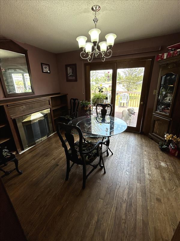 803 Coates St, Macon, MO 63552 - dining space featuring a textured ceiling, dark wood-style floors, and an inviting chandelier