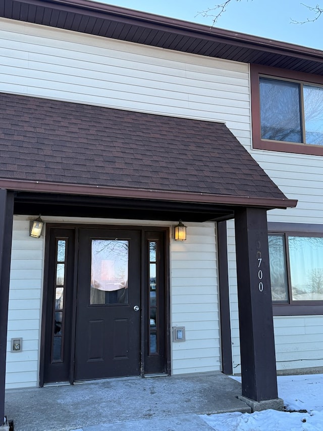 doorway to property featuring a shingled roof