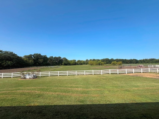 view of yard featuring fence and a rural view