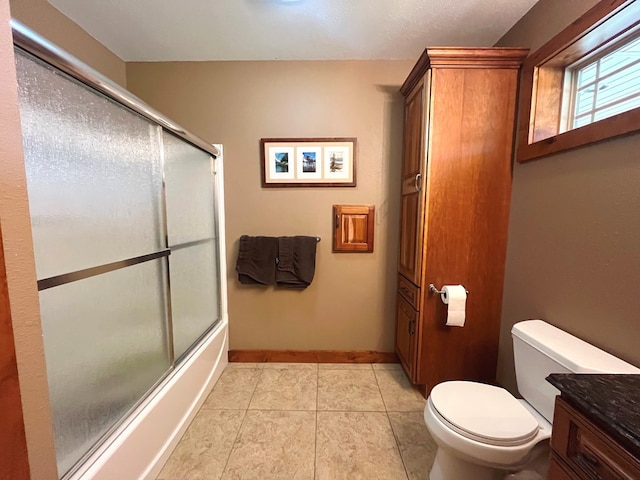 full bath with baseboards, toilet, shower / bath combination with glass door, tile patterned floors, and vanity