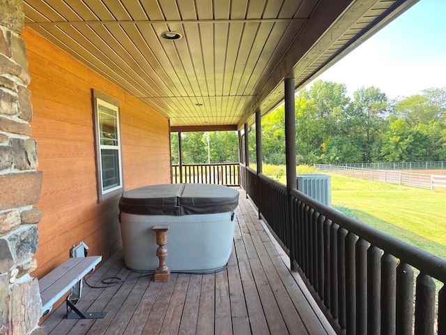 wooden terrace featuring a yard, central AC unit, and a hot tub