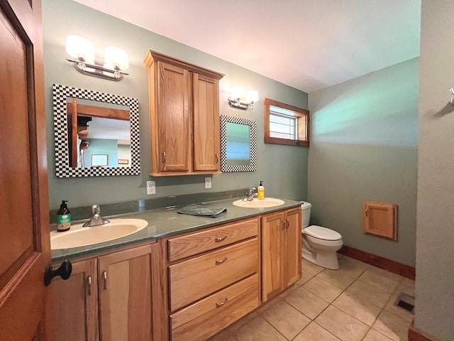 bathroom with visible vents, double vanity, a sink, and toilet