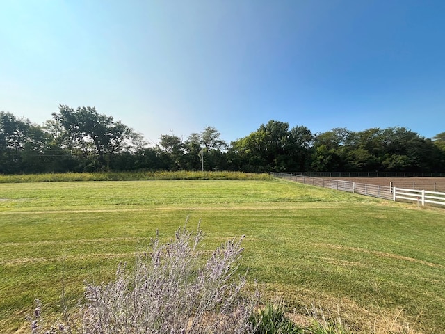 view of yard with a rural view and fence