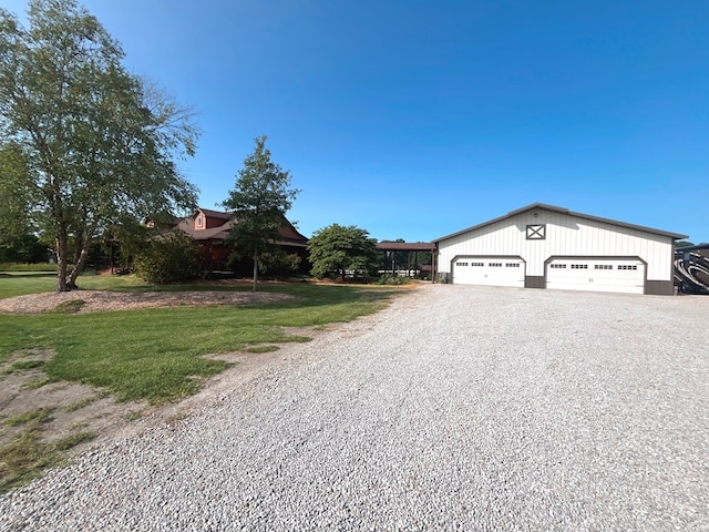 view of front of house featuring a front lawn and a detached garage