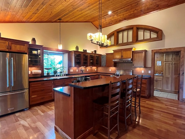 kitchen featuring wooden ceiling, high quality fridge, under cabinet range hood, and a sink