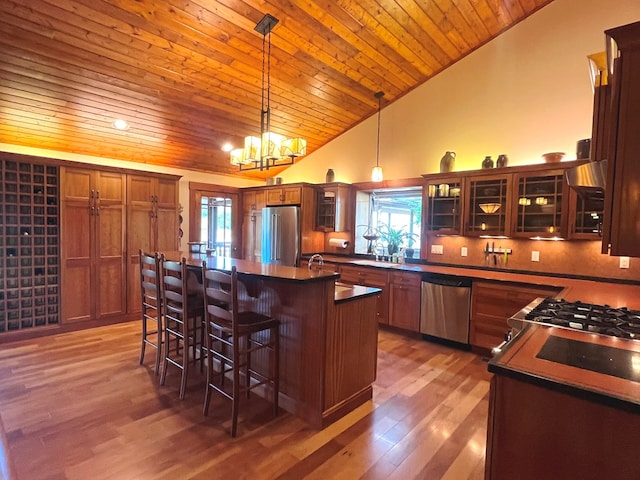 kitchen with dark countertops, plenty of natural light, appliances with stainless steel finishes, and a breakfast bar