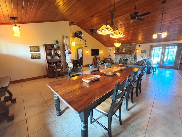 tiled dining room with a fireplace, a ceiling fan, wood ceiling, vaulted ceiling, and baseboards