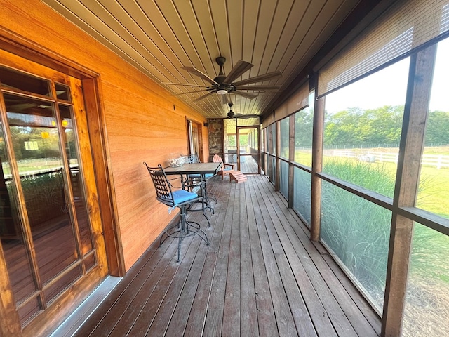 unfurnished sunroom with wooden ceiling and ceiling fan