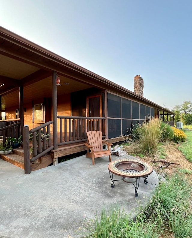 rear view of property with a sunroom and a chimney