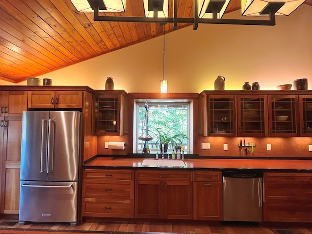 kitchen with vaulted ceiling, appliances with stainless steel finishes, a sink, and wood ceiling