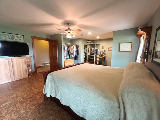 bedroom with ceiling fan, visible vents, and a textured ceiling