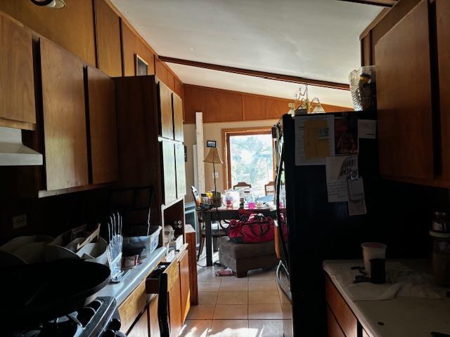 26462 Haven Way, Kirksville, MO 63501 - kitchen with vaulted ceiling, exhaust hood, light tile patterned floors, light countertops, and brown cabinetry
