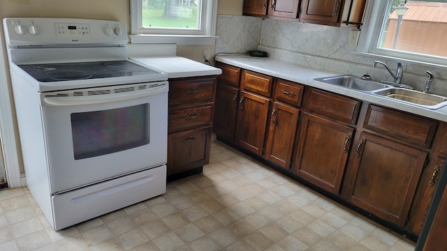 1408 S Downing, Kirksville, MO 63501 - kitchen featuring electric range, light countertops, light floors, and tasteful backsplash