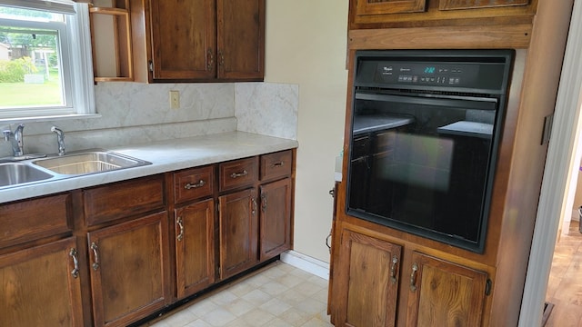 1408 S Downing, Kirksville, MO 63501 - kitchen featuring black oven, light countertops, and backsplash