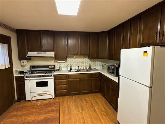 1201 Maffry St, Macon, MO 63552 - kitchen featuring white appliances, range hood, a sink, light wood finished floors, and light countertops