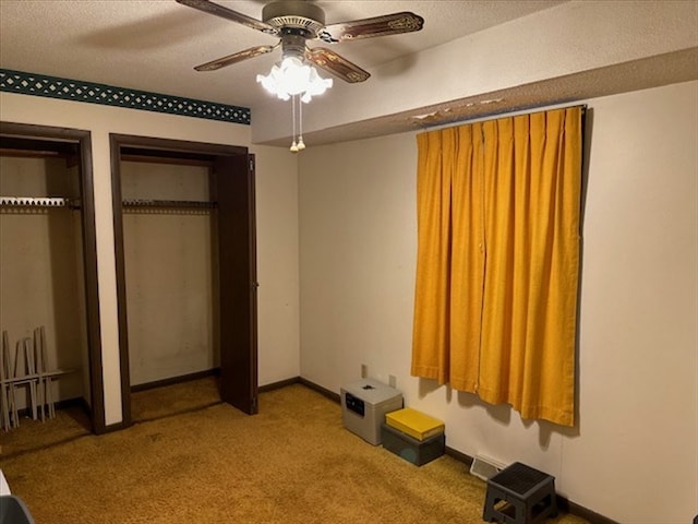 1201 Maffry St, Macon, MO 63552 - unfurnished bedroom featuring two closets, carpet floors, a ceiling fan, and a textured ceiling