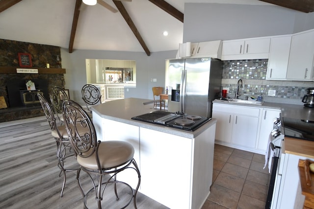 26672 Spring Lake Trl, Kirksville, MO 63501 - kitchen with appliances with stainless steel finishes, a sink, a kitchen island, beamed ceiling, and decorative backsplash