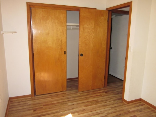 1404 E Washington St, Kirksville, MO 63501 - unfurnished bedroom with baseboards, wood finished floors, and a closet